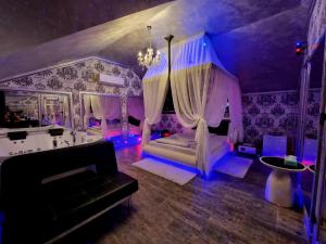 ein lila Zimmer mit einem Bett und einem Sofa in der Unterkunft Anadi Hotel Boutique in Braşov