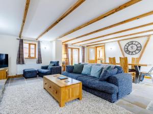 ein Wohnzimmer mit einem blauen Sofa und einem Tisch in der Unterkunft Barn View in Clay Cross