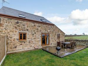 a stone cottage with a table and chairs in front of it at Barn View in Clay Cross