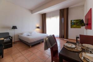 Cerise Carcassonne Sud في قرقشونة: غرفة في الفندق مع سرير وطاولة طعام