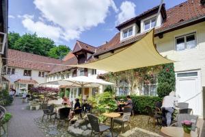 eine Gruppe von Personen, die an Tischen im Innenhof sitzen in der Unterkunft Haus Weitblick Lia in Flensburg