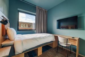 a room with a bed and a desk and a window at Smarthotel Bodø in Bodø