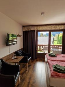 a hotel room with a bed and a table and chairs at Gästehaus Geist Inkl, Chiemgau Karte in Ruhpolding