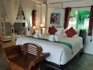 een slaapkamer met een groot wit bed en 2 handdoeken bij Nan De Panna Resort and Spa in Nan