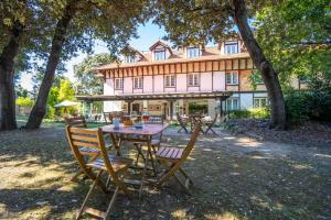 een tafel en stoelen voor een groot huis bij Hotel Torres de Somo in Somo