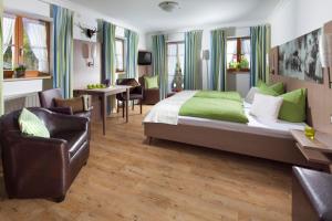 a hotel room with a large bed and chairs at Gästehaus und Ferienwohnungen Egglerlehen in Schönau am Königssee