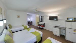 um quarto de hotel com duas camas e uma televisão em Azalea Motel em Coonabarabran