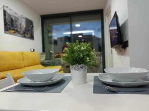 une table avec deux plaques blanches et une plante en pot dans l'établissement Centro Torremolinos Apto 1 hab 1-4 personas WiFi Terraza, à Torremolinos