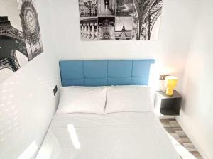 - un lit avec une tête de lit bleue dans l'établissement Centro Torremolinos Apto 1 hab 1-4 personas WiFi Terraza, à Torremolinos