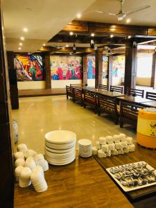 a dining room with white plates and tables in a room at Hotel Satyug Inn in Ujjain