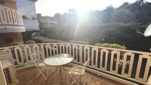 eine Terrasse mit einem Tisch und Stühlen auf dem Balkon in der Unterkunft La Ninfa in Acitrezza