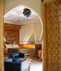 sypialnia z łóżkiem i niebieskim krzesłem w obiekcie Riad Moucharabieh Matisse w Marakeszu