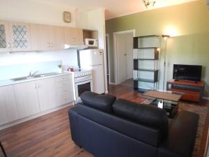 sala de estar con sofá y cocina en Burnie Port Views, en Burnie