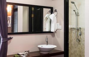 a bathroom with a sink and a shower with a mirror at The Beehive in Male City