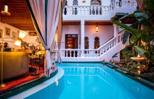 a swimming pool in a hotel with a restaurant at Riad Moucharabieh Matisse in Marrakesh