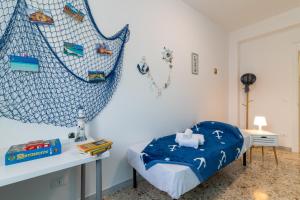 a bedroom with a bed with a blue blanket at Cherry Blossom - Affitti Brevi Italia in Palermo