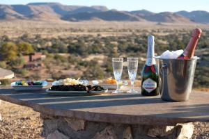 a table with champagne and plates of food and glasses at Duwisib Guest Farm in Duwisib