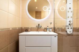 y baño con lavabo blanco y espejo. en Centrally-located 1BD Apartment near Kapana, en Plovdiv
