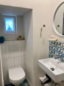 a bathroom with a white toilet and a sink at wohnen auf dem Weingut - klein und fein in Maring-Noviand