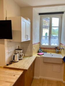 a kitchen with white cabinets and a sink and a window at wohnen auf dem Weingut - klein und fein in Maring-Noviand
