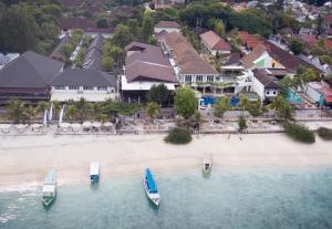 three boats in the water on a beach at Natya Hotel Gili Trawangan in Gili Trawangan