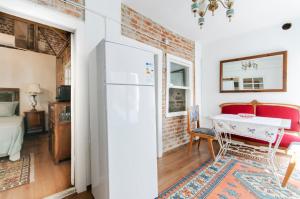 a kitchen with a white refrigerator and a table at Iconic Stone Houses in İzmir