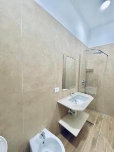 La salle de bains est pourvue d'un lavabo et d'un miroir. dans l'établissement Flors Apartments, à Durrës