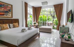 a bedroom with a large bed and a large window at Utapao sattahip rayong resort in Ban Nong Sa