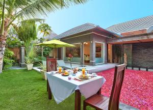 a table with food and an umbrella in a backyard at The Buah Bali Villas in Seminyak
