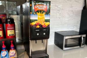 a drink dispenser next to a microwave and a drink dispenser at Days Inn & Suites by Wyndham Opelousas in Opelousas