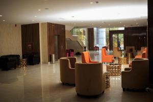 a lobby with orange chairs and a waiting room at El Doria Hotel in Lomé