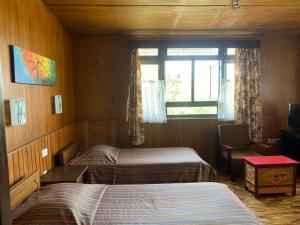 a hotel room with two beds and a window at Mintokling Guest House in Gangtok