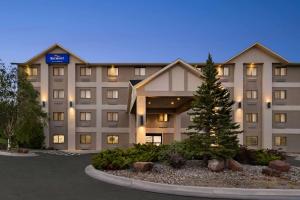 a hotel with a christmas tree in front of it at Baymont by Wyndham Elko in Elko