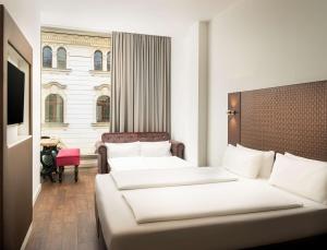 ライプツィヒにあるelaya hotel leipzig city centerのベッド2台と窓が備わるホテルルームです。