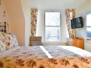 um quarto com uma cama, uma televisão e uma janela em Brighton House em Nairn