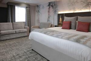 a hotel room with a large bed and a couch at Barton Manor Hotel & Spa; BW Signature Collection in Preston