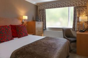 Pokój hotelowy z łóżkiem, krzesłem i oknem w obiekcie Barton Manor Hotel & Spa; BW Signature Collection w mieście Preston