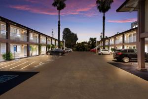 a parking lot with palm trees and cars parked at SureStay Plus Hotel by Best Western Mountain View in Mountain View