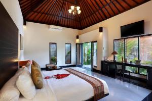 a bedroom with a large bed in a room with windows at Askara Villa in Canggu +100 photos