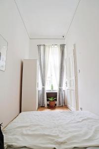 a white bedroom with a bed and a window at Beautiful apartment in 7th district in Budapest