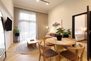 uma sala de estar com uma mesa e cadeiras num quarto em Hyatt House Johannesburg Rosebank em Joanesburgo