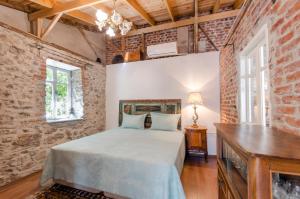 Un dormitorio con una cama y una pared de ladrillo. en Iconic Stone Houses, en Izmir