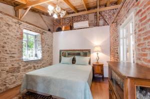 a bedroom with a bed and a brick wall at Iconic Stone Houses in İzmir