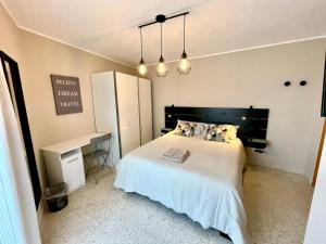 een slaapkamer met een groot wit bed en een bureau bij B&B La finestra sulle Mainarde - Isernia in Isernia