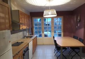 a kitchen with a table and a large window at Farole,Gite de charme in Fort-Mahon-Plage