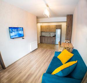 a living room with a blue couch and a kitchen at Cozy Apartment in Bakuriani in Bakuriani