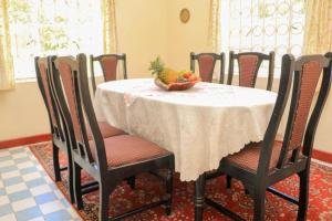 a dining room table with a bowl of fruit on it at Nyahururu Highlands Heaven -BnB in Nyahururu