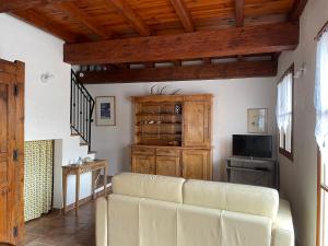sala de estar con sofá y TV en Le Castellaras - La Manonegra - Entre mer et montagne, endroit typique, nature, calme en Bézaudun-les-Alpes