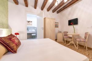 1 dormitorio con 1 cama, mesa y sillas en Residenza San Silvestro, en Venecia