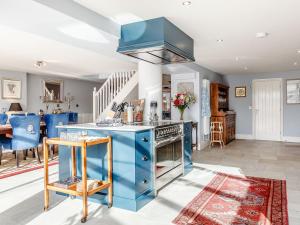 Whitecroft的住宿－Claysun House，一间设有蓝色橱柜和蓝色岛屿的厨房